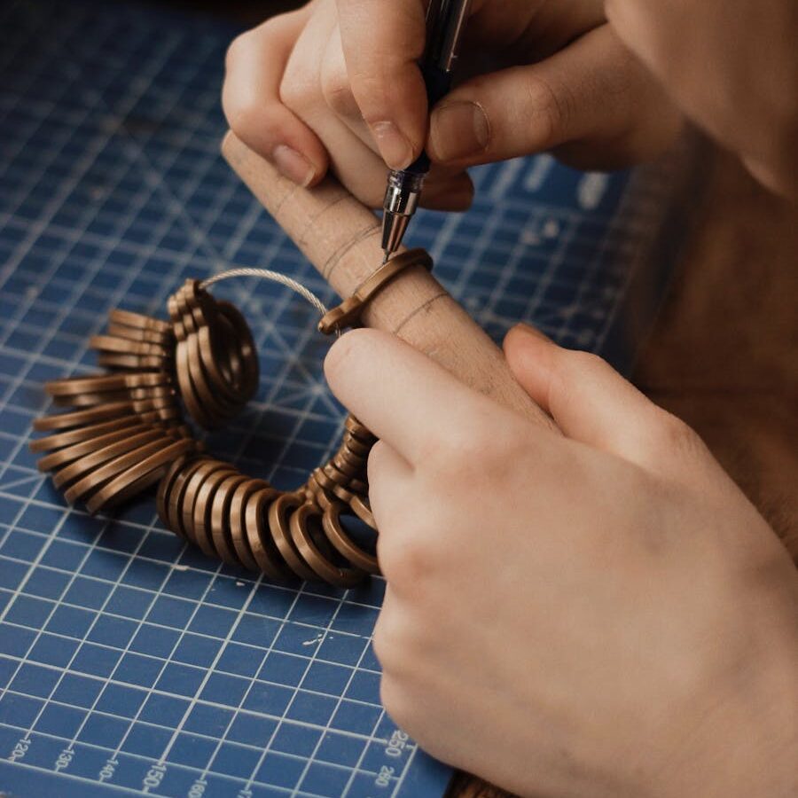 Person Using a Finger Ring Gauge and Wooden Cylindrical Tool