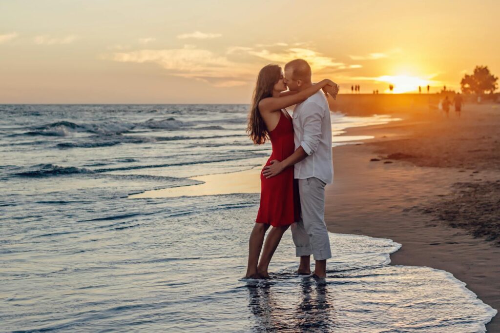 romantic sunset beach scene with a couple walking hand in hand